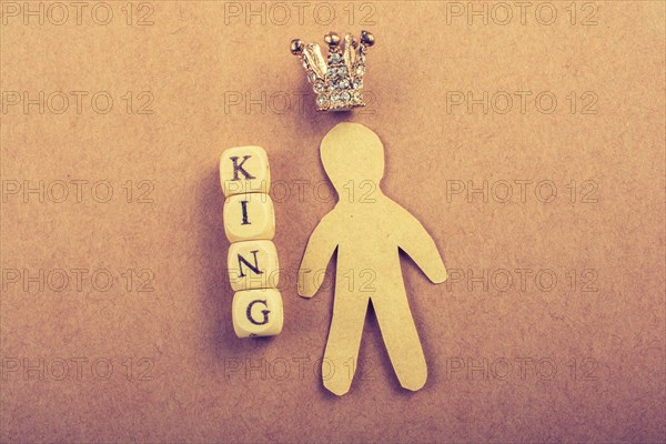 Tiny model crown beside the king wording on brown