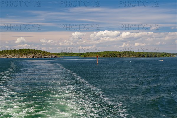 View from a ferry over flat islands with rocks and forest