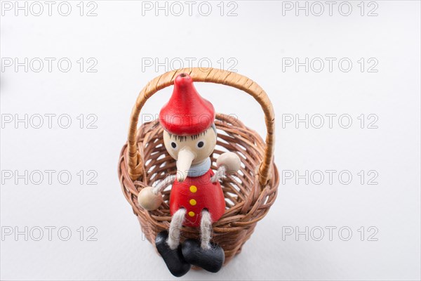 Pinochio toy figurine sitting in a straw basket