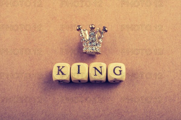 Tiny model crown beside the king wording on brown