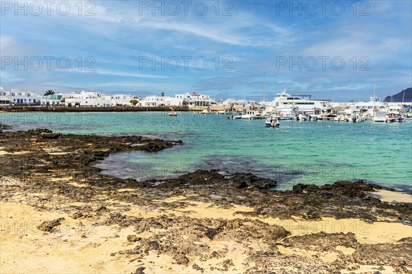 Beach and port with boats and ferries in Caleta del Sebo