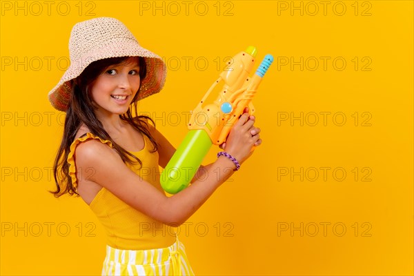 Portrait of a girl with a water pistol on summer vacation