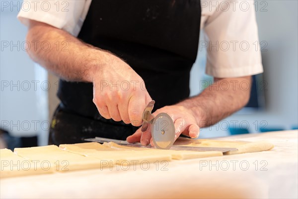 Detail of the hands of a man baking croissants