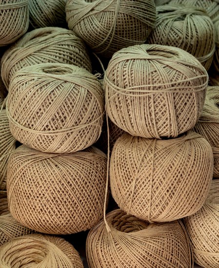Plenty of spools or rolls of brown color linen string