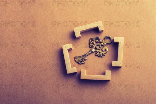 Retro style key in wooden brackets on wooden background