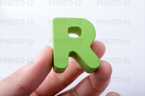 Hand holding letter cube R of made of wood