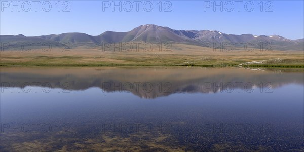 Mountains reflecting in a lake along the At-Bashy Range