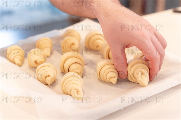 Hands of a man baking small croissants at home