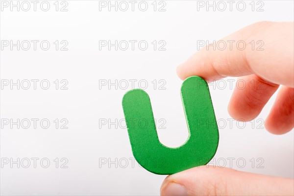 Hand holding letter cube U of made of wood