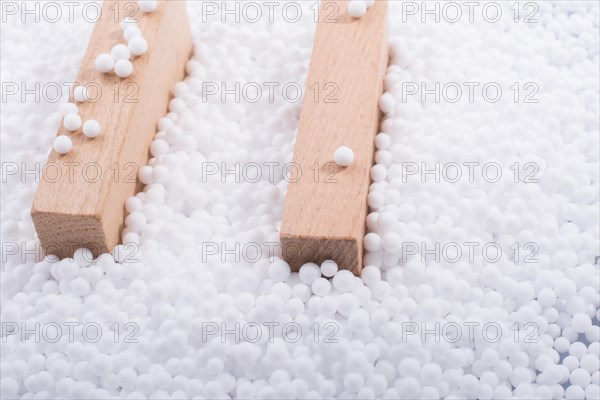 Wooden blocks in White polystyrene foam balls as background