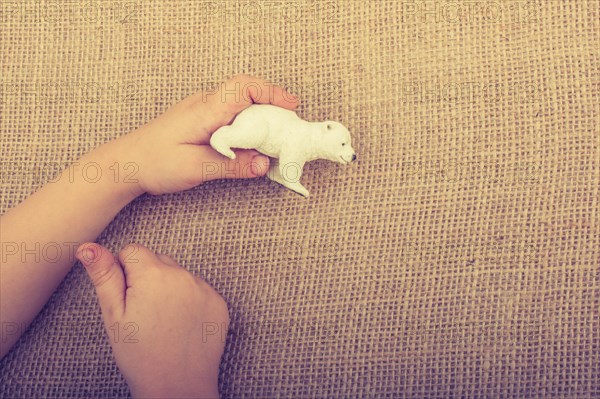 Hand holding a Polar bear model in hand on canvas