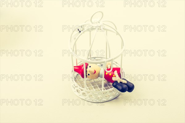 Metal cage and Little puppet pinocchio made of wood