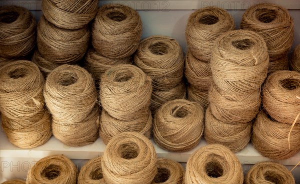 Plenty of spools or rolls of brown color linen string