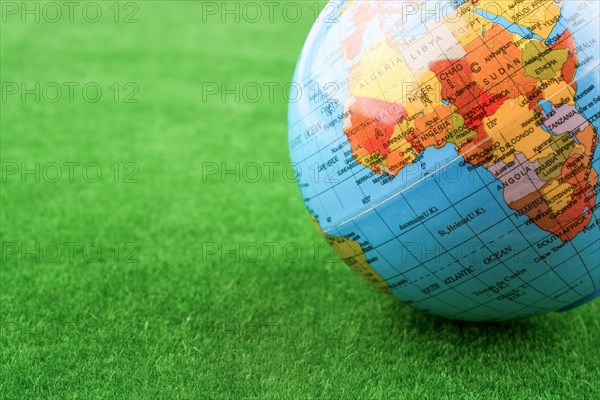 Litltle model globe placed on green grass