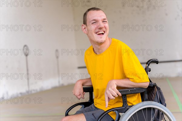 Portrait of a disabled person in a wheelchair at a Basque pelota game fronton smiling