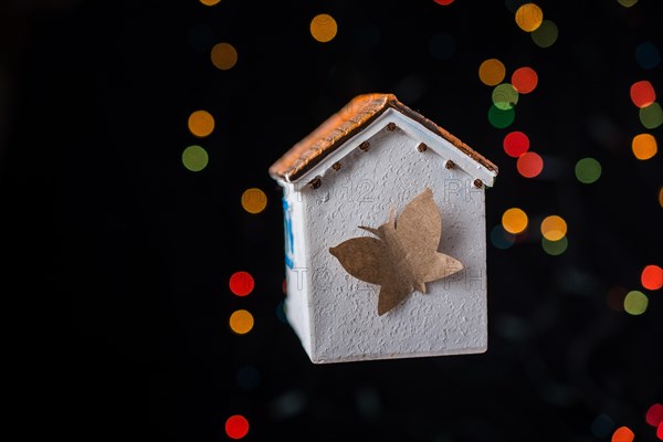 Paper butterfly on a Model house on a bokeh light