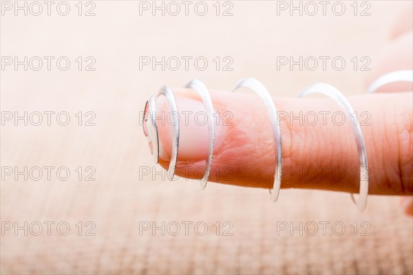 Steel spiral spring in a finger on a textured background