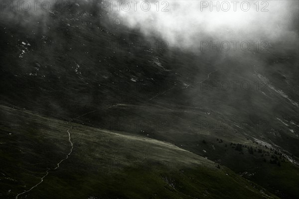 Mountain path in mountain meadow with remains of fog