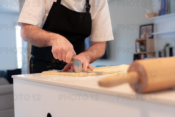 Detail of the hands of a man baking croissants