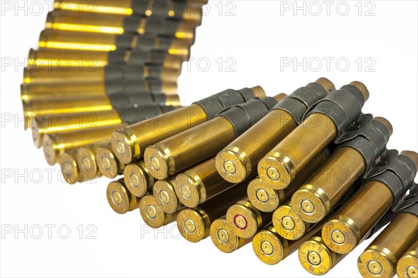 50 Caliber machine gun cartridges in ammunition belt against white background