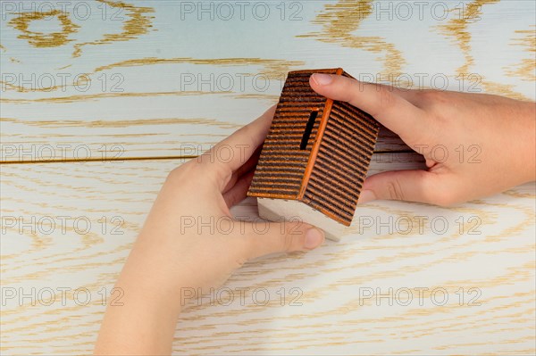 Little model housein hand on a parquet background