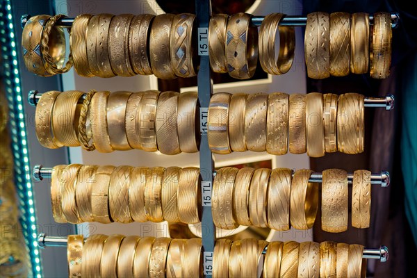 Shop display of dozens of golden bracelets and bangles