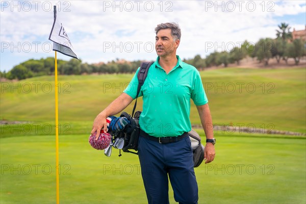 A professional golf player on a golf course next to the flag on the green