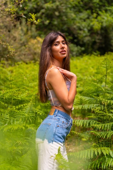 Portrait of a Caucasian girl in ferns on a mountain surrounded by nature