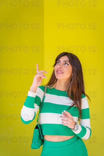 Caucasian girl pointing up with copy space