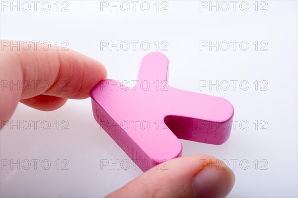 Hand holding letter cube K of made of wood