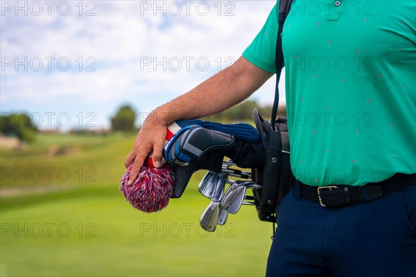 A professional golf player with the bag of clubs ready to play golf