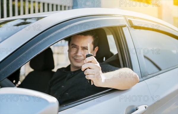 Happy man showing his new car keys