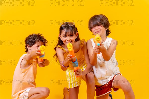 Kids having fun with water guns on summer vacation