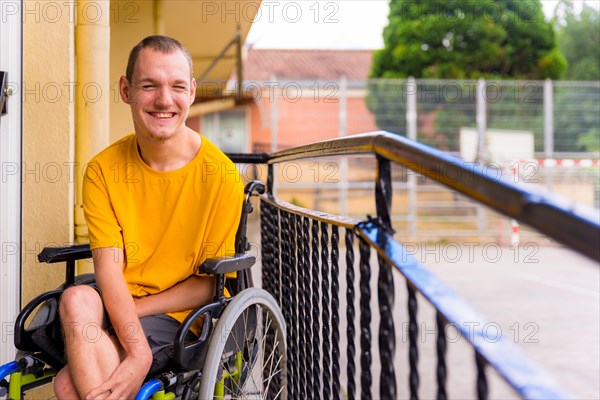 Disabled person dressed in yellow in a wheelchair at school smiling