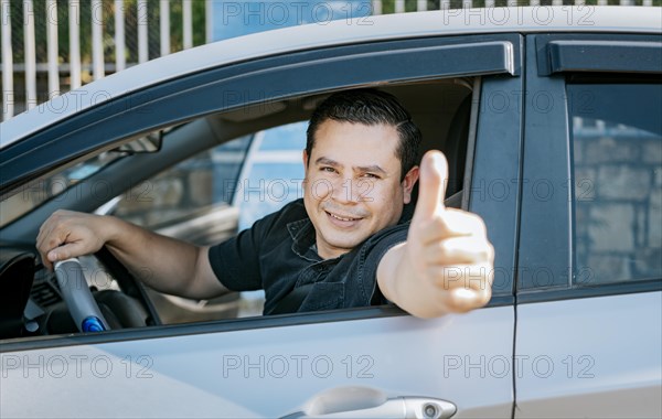 Happy Driver giving a thumbs up. Satisfied driver man showing thumb up. Concept of satisfied car owner