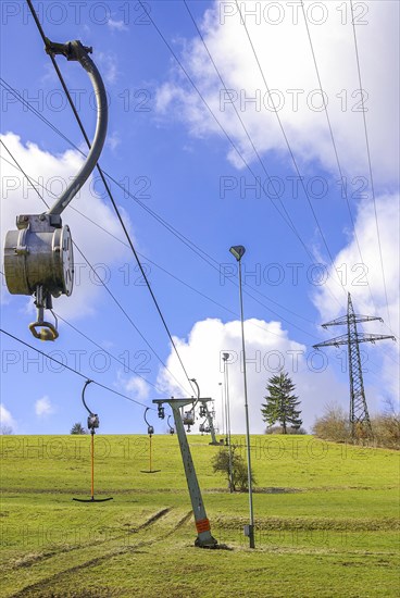 Ski lift at standstill due to lack of snow caused by climate change at the end of winter on a hill in Muensingen