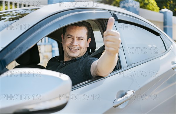 Man in his car giving thumbs up