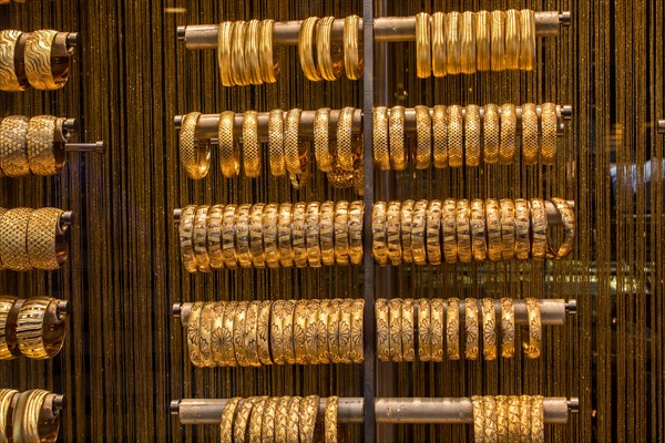 Shop display of dozens of golden bracelets and bangles