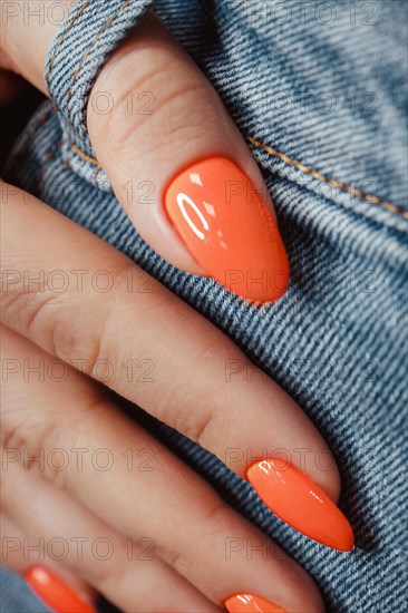 Bright neon manicure on female hands on the background of jeans. Nail design. Beauty hands