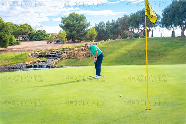 Playing golf at golf club by a lake on the green