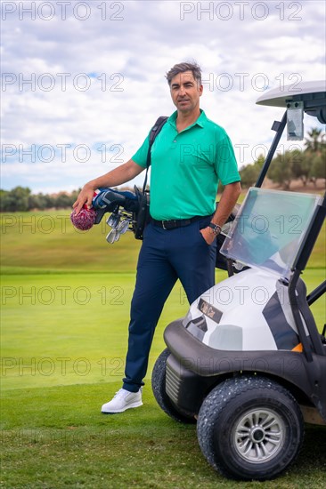 A professional golf player in a green polo shirt with the bag of clubs