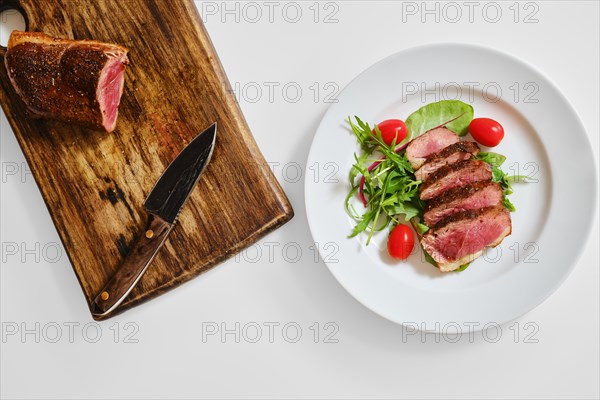 Top view of grilled duck breast medium rare served on a plate