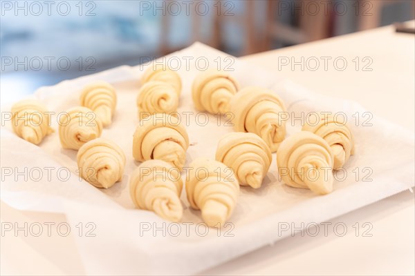 Hands of a man baking small croissants at home