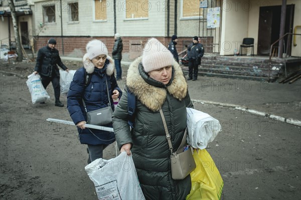 Residents of the house destroyed by a Russian missile attack that killed 45 people move their belongings from their homes