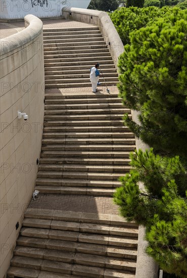 Elderly woman cleaning the steps at the Olympic site Lluis Companys