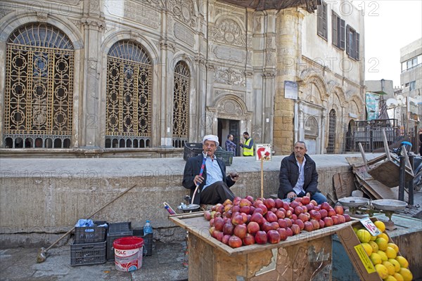 Egyptian man smoking shisha or hookah at a fruit stall