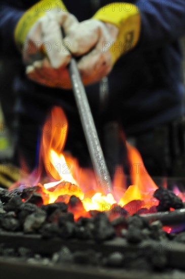 Glowing iron in glowing coal in a forging forge