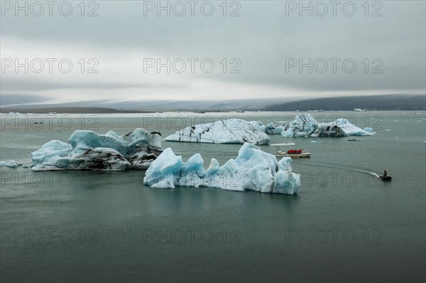 Icebergs and excursion boat in the Joekulsarlon glacier lagoon