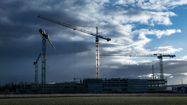 Construction cranes on a building site in Augsburg on the Bundesstrasse 17