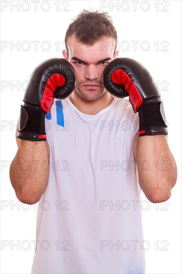 Aggressive determined young male boxer protecting his face with his fists in boxing gloves on his hat on both sides